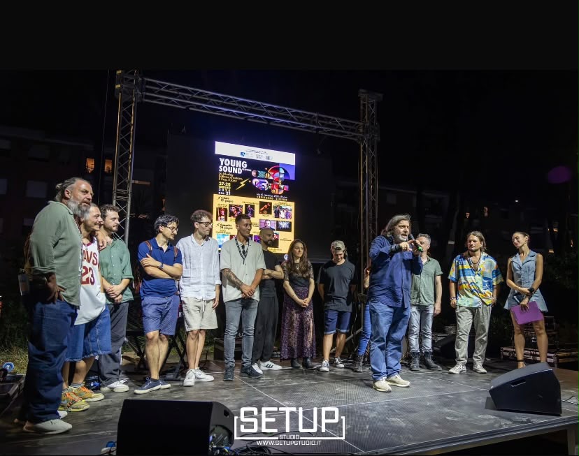 Artisti e ospiti riuniti sul palco durante un evento musicale
