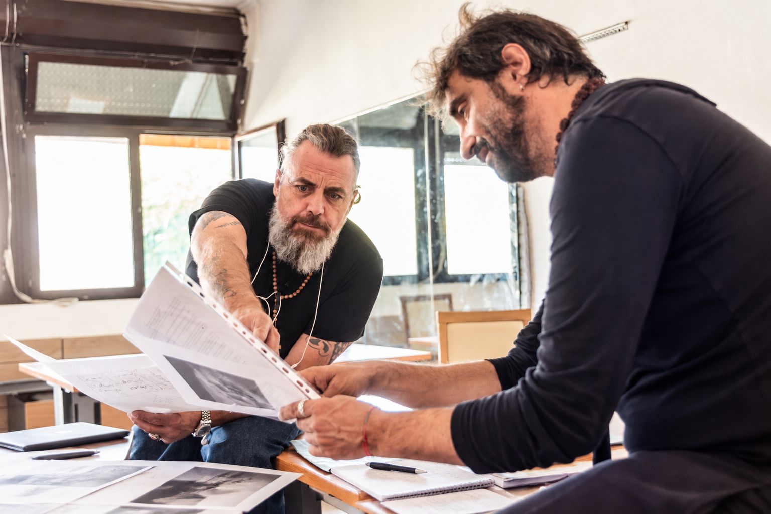 Due persone discutono materiali di lavoro su un tavolo