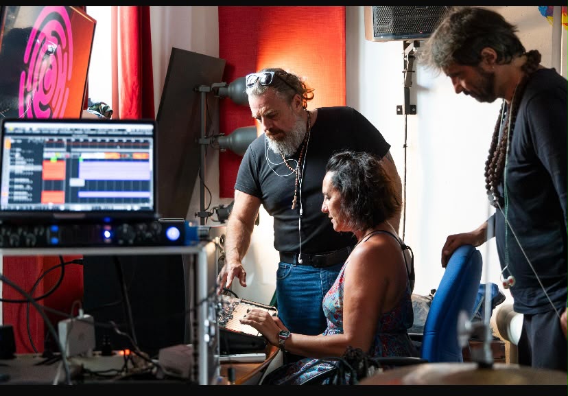 Tre persone collaborano davanti a una postazione di produzione audio